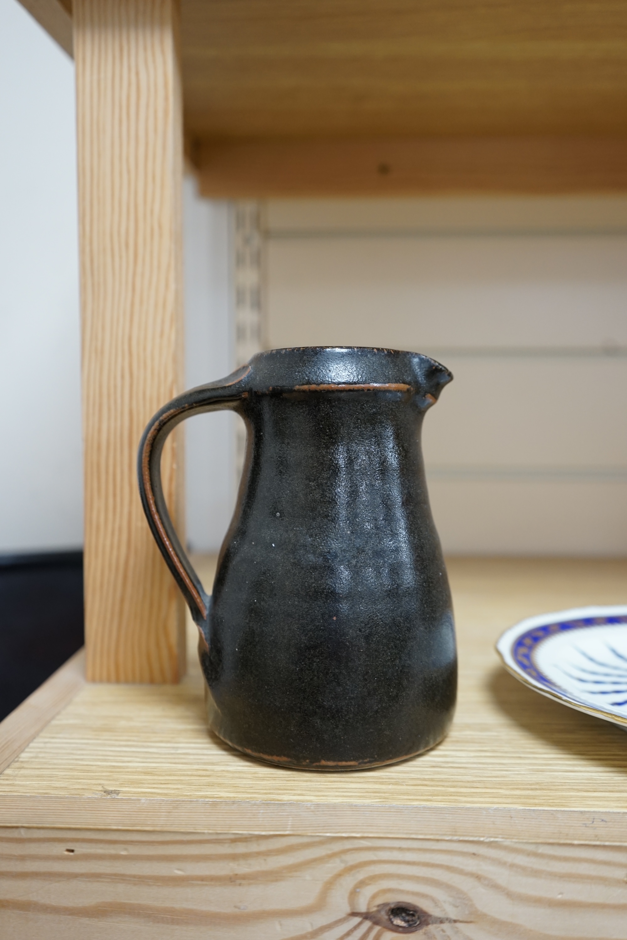 Leach standard ware, a small Stoneware black glazed studio pottery jug, impressed mark to top of foot rim, 15.5cm high. Condition - good